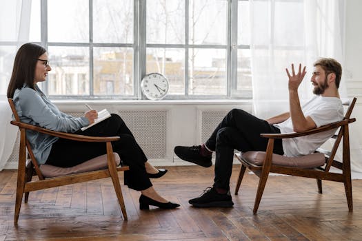 A therapist engaging in a counseling session with a male patient to support mental health.